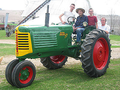 Joseph, Wayne, Daniel, and Russ pose by the newly-restored Oliver 77 tractor, used on the farm since it was purchased new in 1951.